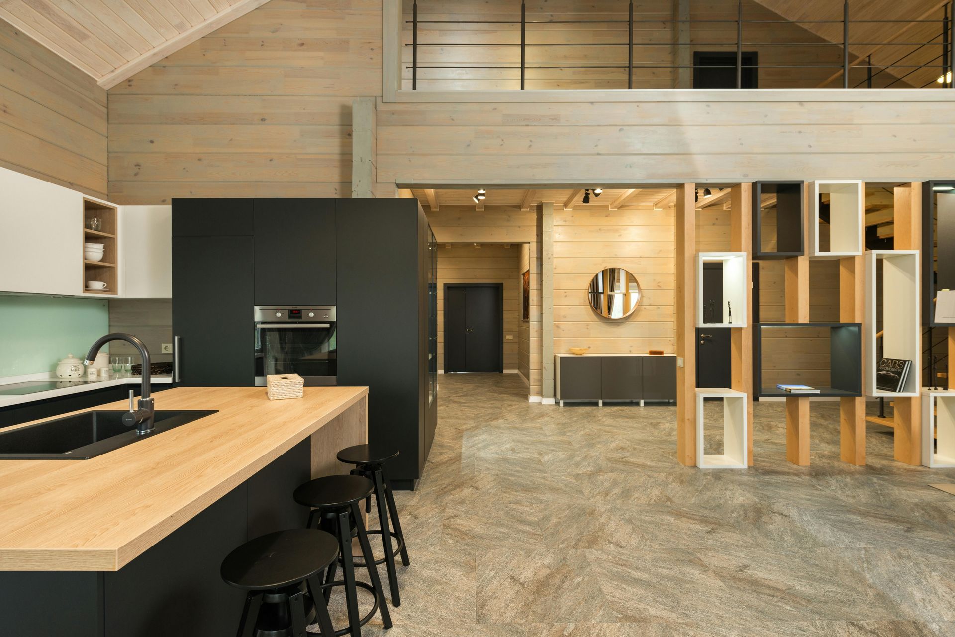 Open plan room with black cabinetry, a timber counter and built-in shelving